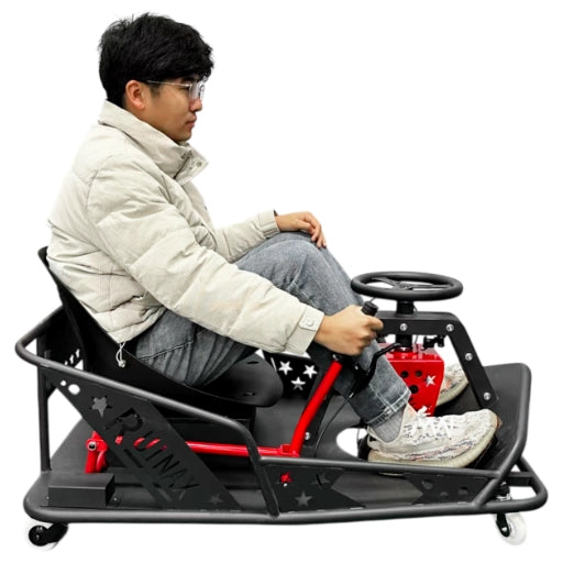 Person sitting on a go-kart style drift cart with a steering wheel, wearing a white jacket and gray pants.